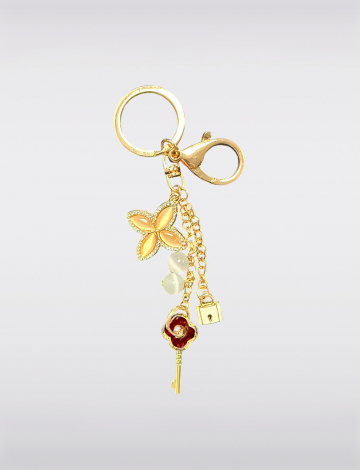 Elegant keychain featuring a gold butterfly charm, adorned with delicate pearls and a small lock detail by Manteaux Manteaux.